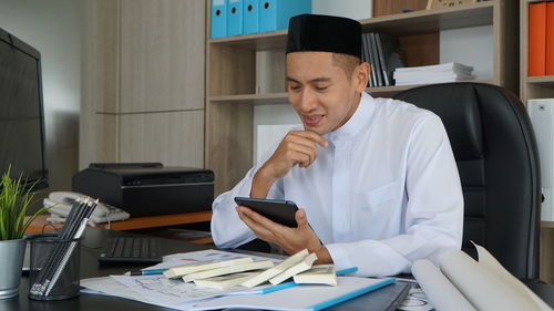 Midsection of woman using mobile phone while sitting in office