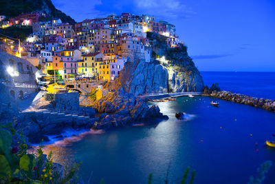 High angle view of townscape by sea against sky at night