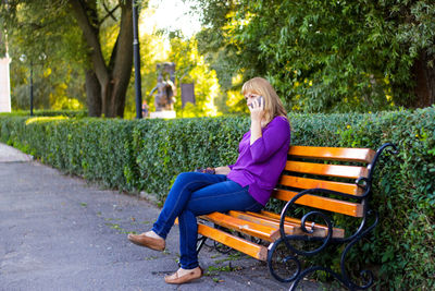 Elegance caucasian blond woman talking, speaking on the phone outside, outdoor. 40s years old woman 