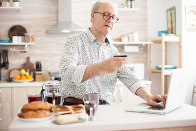 Man using laptop on table at home