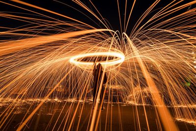 Man spinning wire wool at night