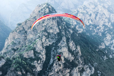 People paragliding on mountain peak