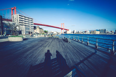 View of bridge in city against blue sky
