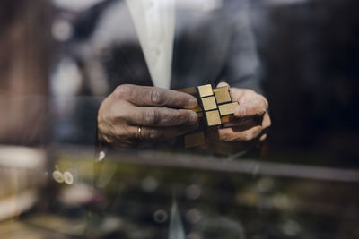 Senior businessman putting together puzzle cube