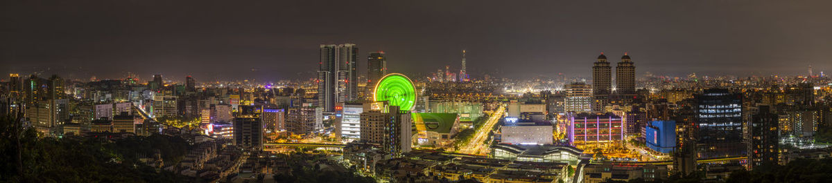 Panoramic view of illuminated buildings against sky at night