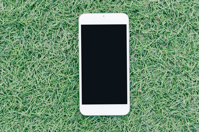 High angle view of smart phone on field