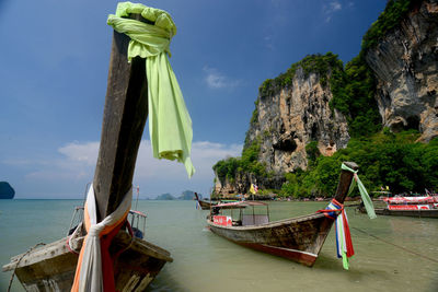 Boat moored on shore against mountains