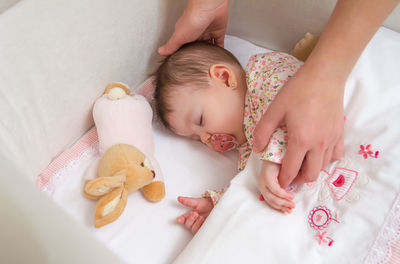 High angle view of baby lying on bed