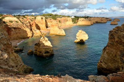 Rock formations by sea against sky