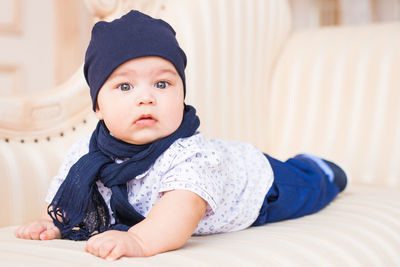 Portrait of cute girl sitting on bed at home