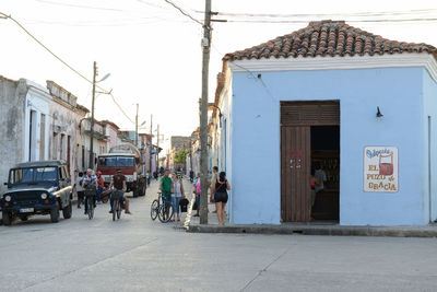 People on street in city against sky