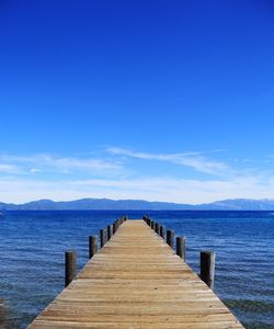 Pier over sea against blue sky