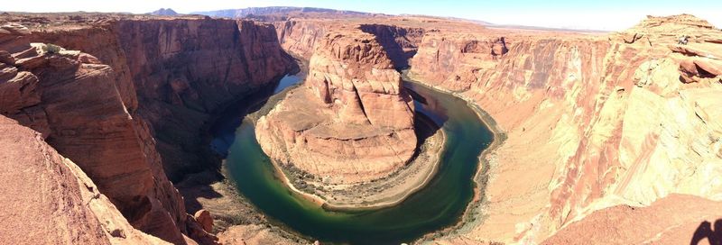 Panoramic view of horseshoe bend on sunny day