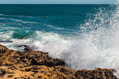 Waves splashing on rocks at sea shore