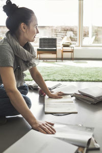 Side view of architect working on floor at home office