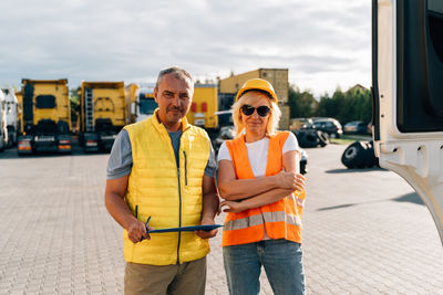 Portrait of truckers standing in front of trucks