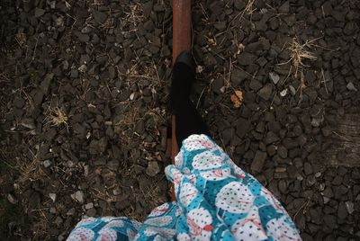 Low section of woman standing on rusty metallic pipe