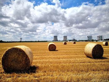 Hay bales on field against sky