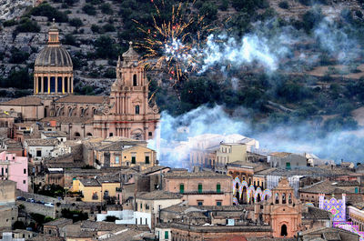 Firework display by buildings in city