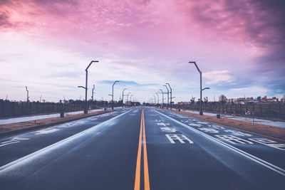 Empty road against cloudy sky