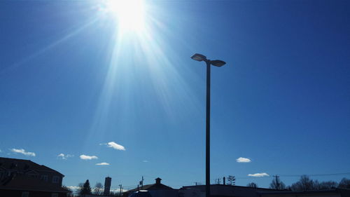 Low angle view of street light against bright sky