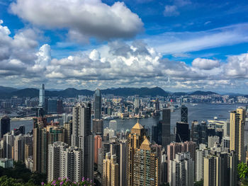 Aerial view of cityscape against cloudy sky