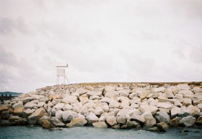 Rocks by sea against sky