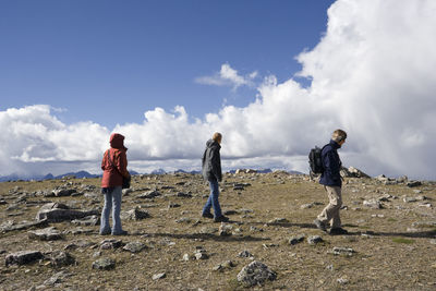 Friends hiking on whistler mountain against cloudy sky