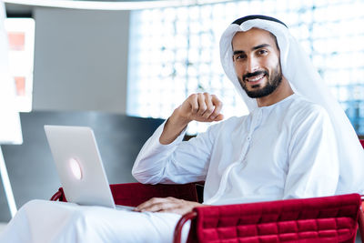 Portrait of young woman using laptop at home