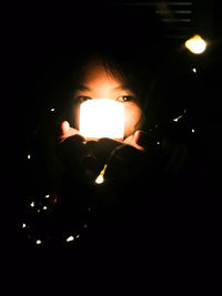 Close-up of man holding lit candle