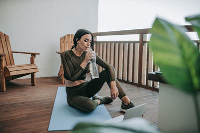 Woman using phone while sitting on table