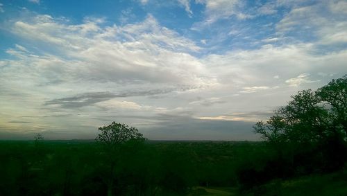 Scenic view of field against cloudy sky