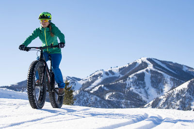 A woman riding her fat bike on a beautiful winter day in sun valley.