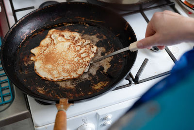 Tasty pancake in a cast-iron pan. fry a delicious pancake in a rustic cast iron skillet. 