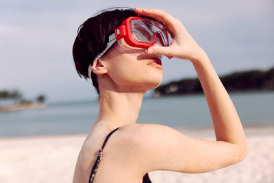 Young woman with arms raised standing at beach