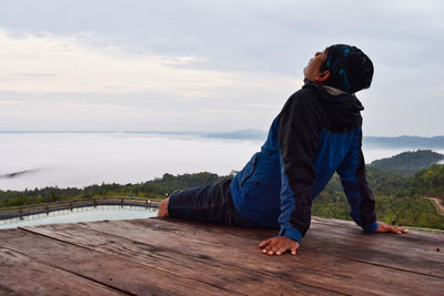 Side view of man on shore against sky