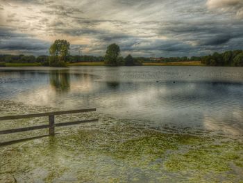 Scenic view of lake against cloudy sky