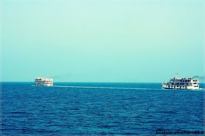 Boats in sea against clear sky