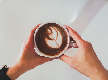 Cropped image of hand holding coffee cup
