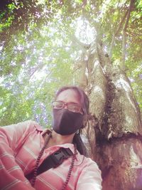 Portrait of man wearing sunglasses against trees