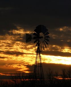 Low angle view of silhouette windmill against sky during sunset