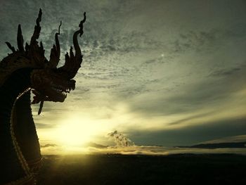 Silhouette cactus on landscape against sky during sunset