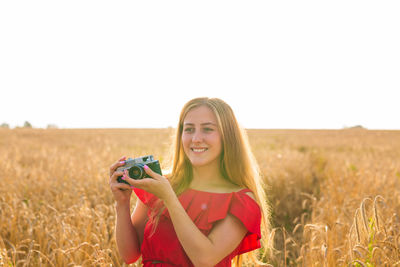 Portrait of smiling young woman on field