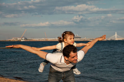 Friends enjoying in sea against sky