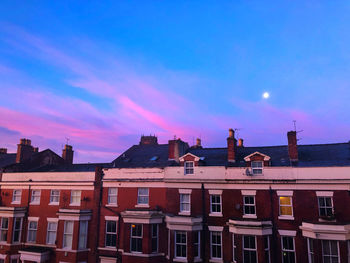 Buildings against cloudy sky at sunset