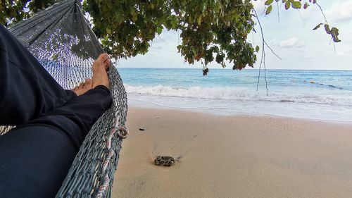 Low section of person relaxing on beach