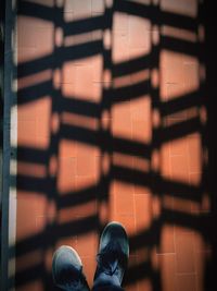 Low section of person standing on tiled floor