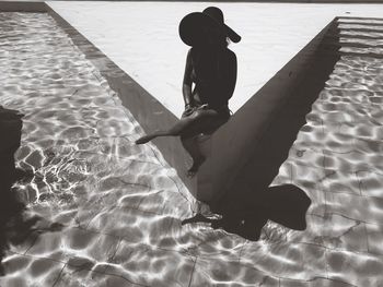 High angle view of woman standing by swimming pool