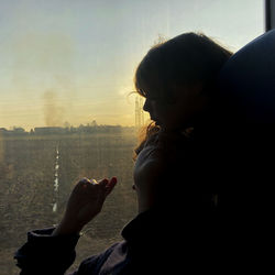 Mother and daughter by train glass window