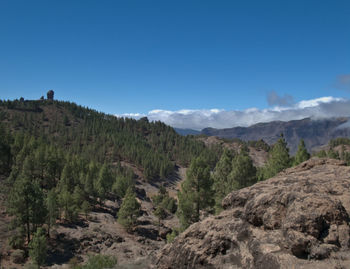 Scenic view of landscape and mountains against blue sky